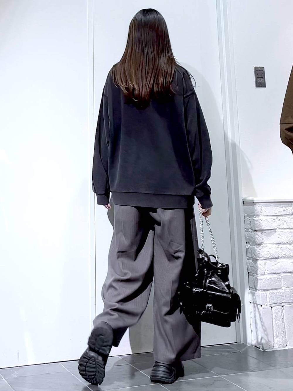 ブラック系のスニーカー、グレー系のスウェット、ブラック系のショルダーバッグを着用したレディースの秋コーディネートの7枚目の写真