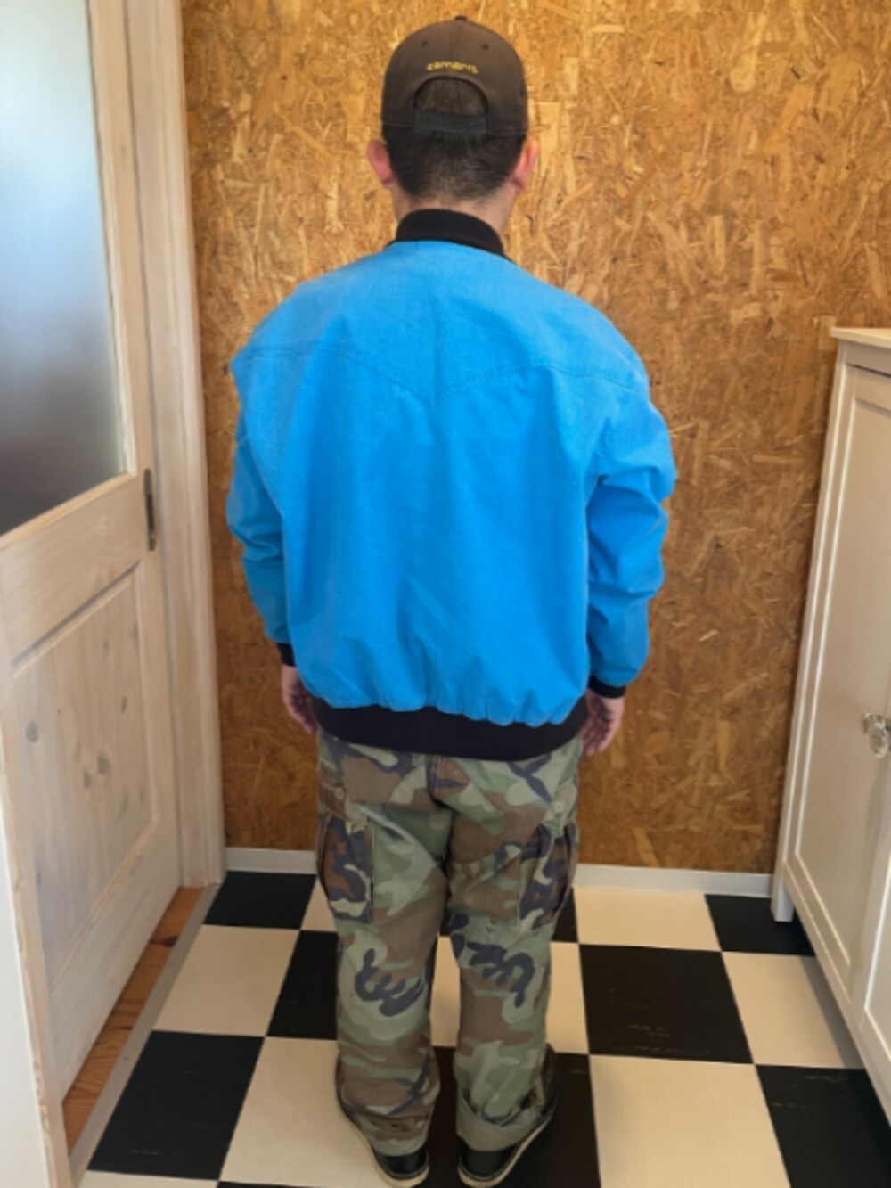 ブルー系のブルゾン、ホワイト系のTシャツ/カットソー、グリーン系のカーゴパンツを着用したメンズの春コーディネートの2枚目の写真