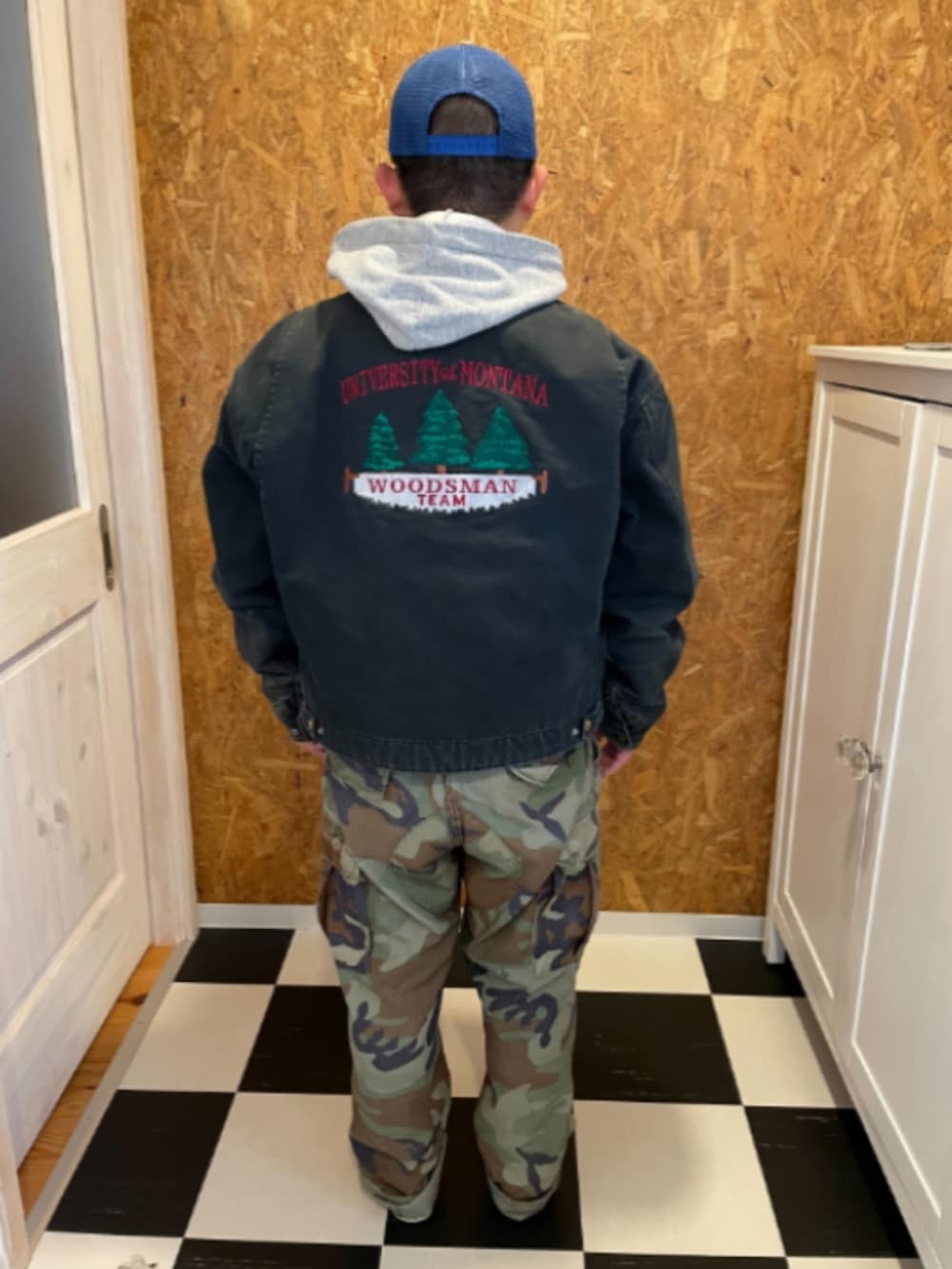 ブラック系のジャケット/アウター、グレー系のパーカー、グリーン系のカーゴパンツを着用したメンズの冬コーディネートの2枚目の写真