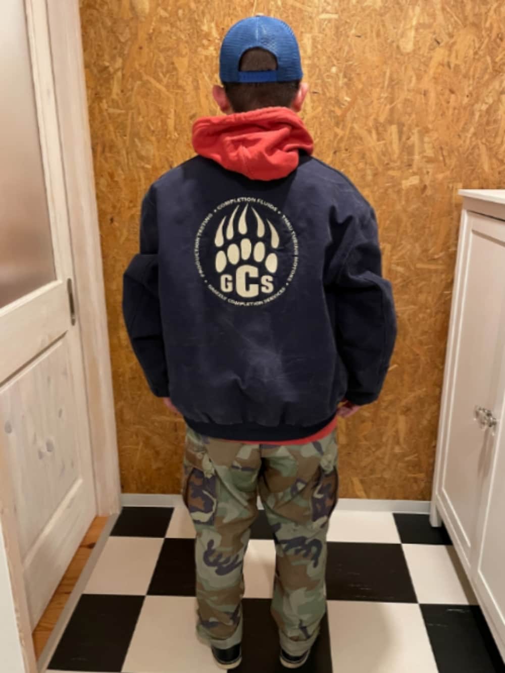 ブルー系のブルゾン、オレンジ系のパーカー、グリーン系のカーゴパンツを着用したメンズの冬コーディネートの2枚目の写真