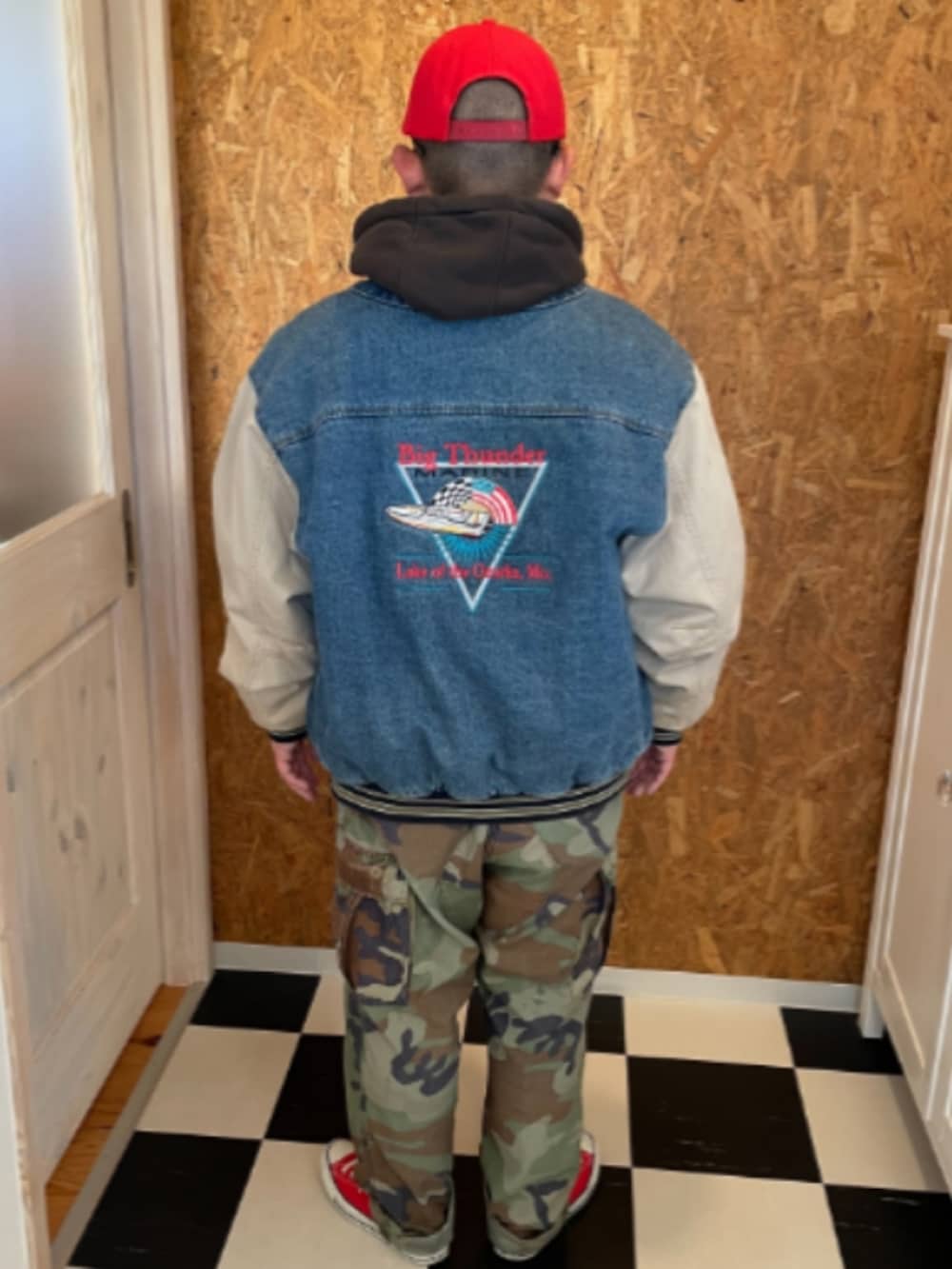 ブラック系のパーカー、ブルー系のブルゾン、グリーン系のカーゴパンツを着用したメンズの冬コーディネートの2枚目の写真