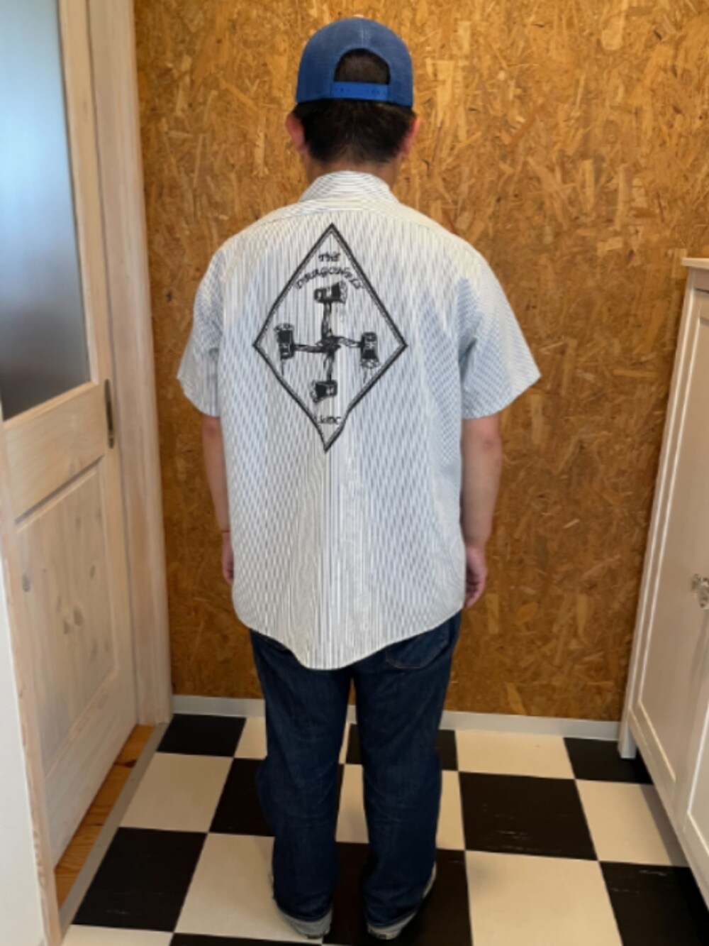 ブルー系のデニムパンツ、グレー系のスニーカー、グレー系のシャツ/ブラウスを着用したメンズの夏コーディネートの2枚目の写真