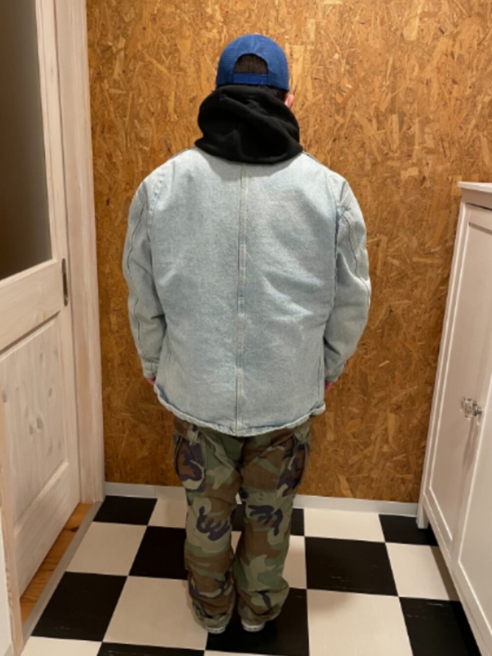 ブラック系のパーカー、ブルー系のジャケット/アウター、グリーン系のカーゴパンツを着用したメンズの冬コーディネートの2枚目の写真