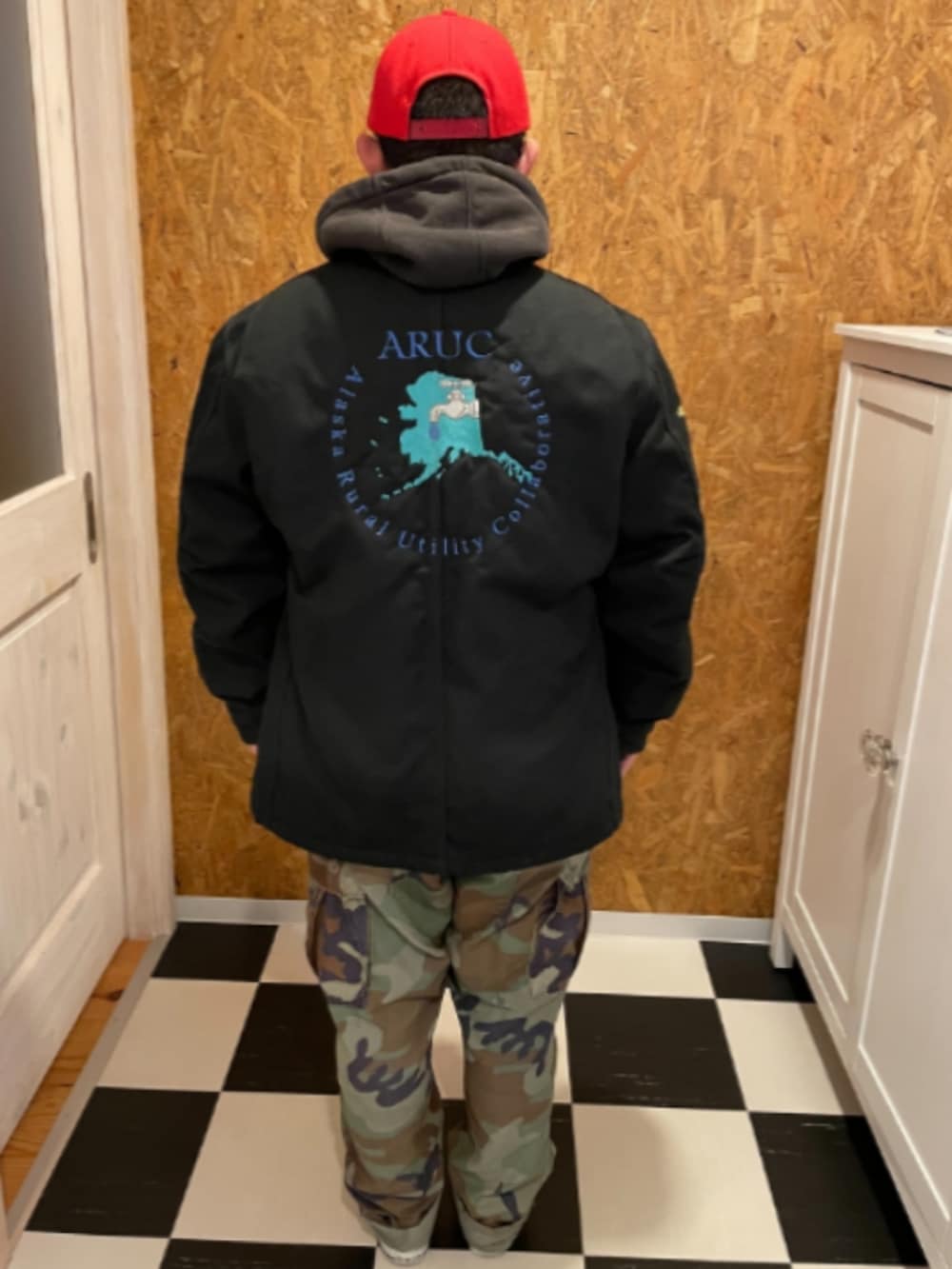 ブラック系のカバーオール、ブラック系のパーカー、グリーン系のカーゴパンツを着用したメンズの冬コーディネートの2枚目の写真