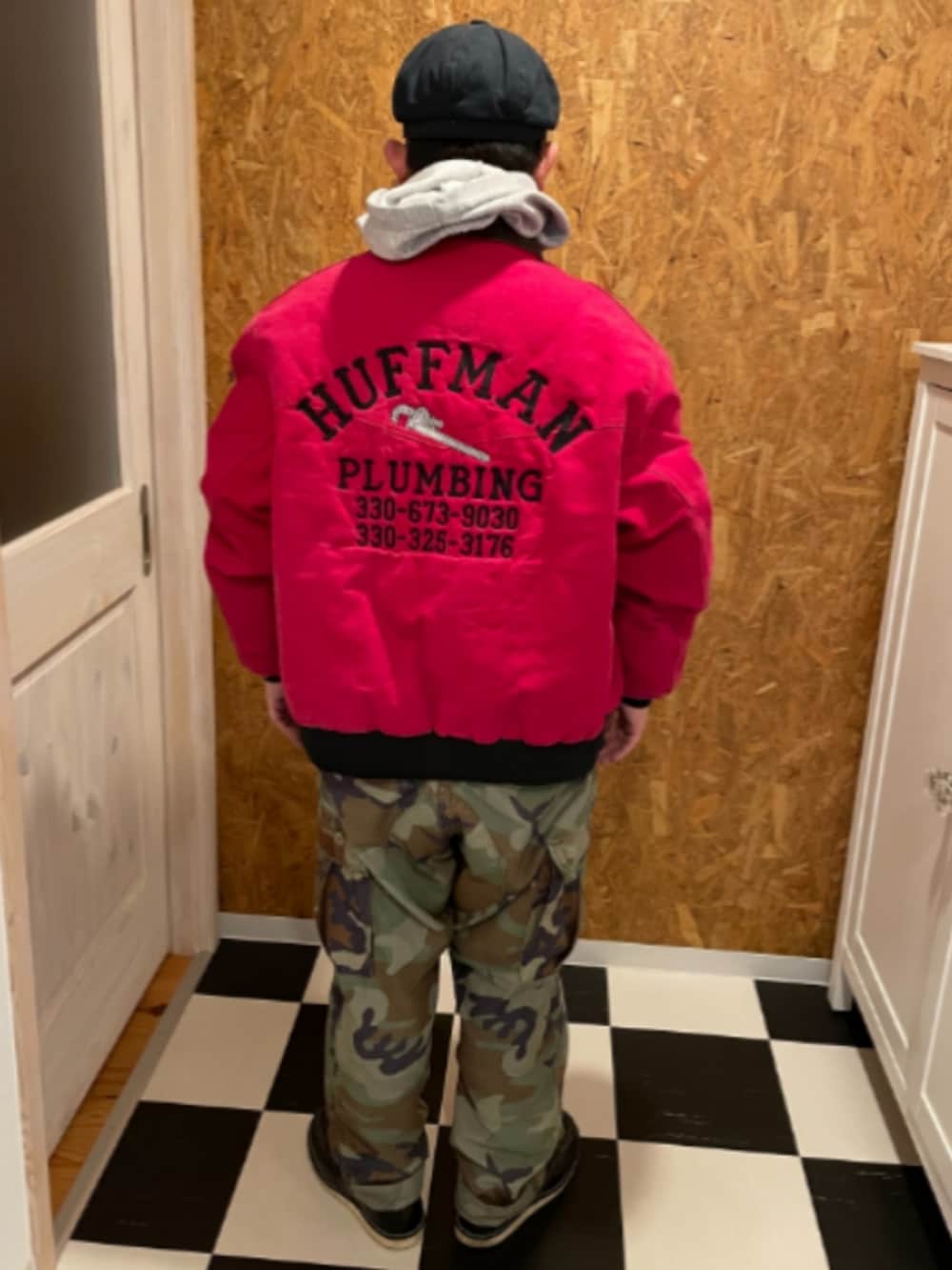 レッド系のブルゾン、グレー系のパーカー、グリーン系のカーゴパンツを着用したメンズの冬コーディネートの2枚目の写真