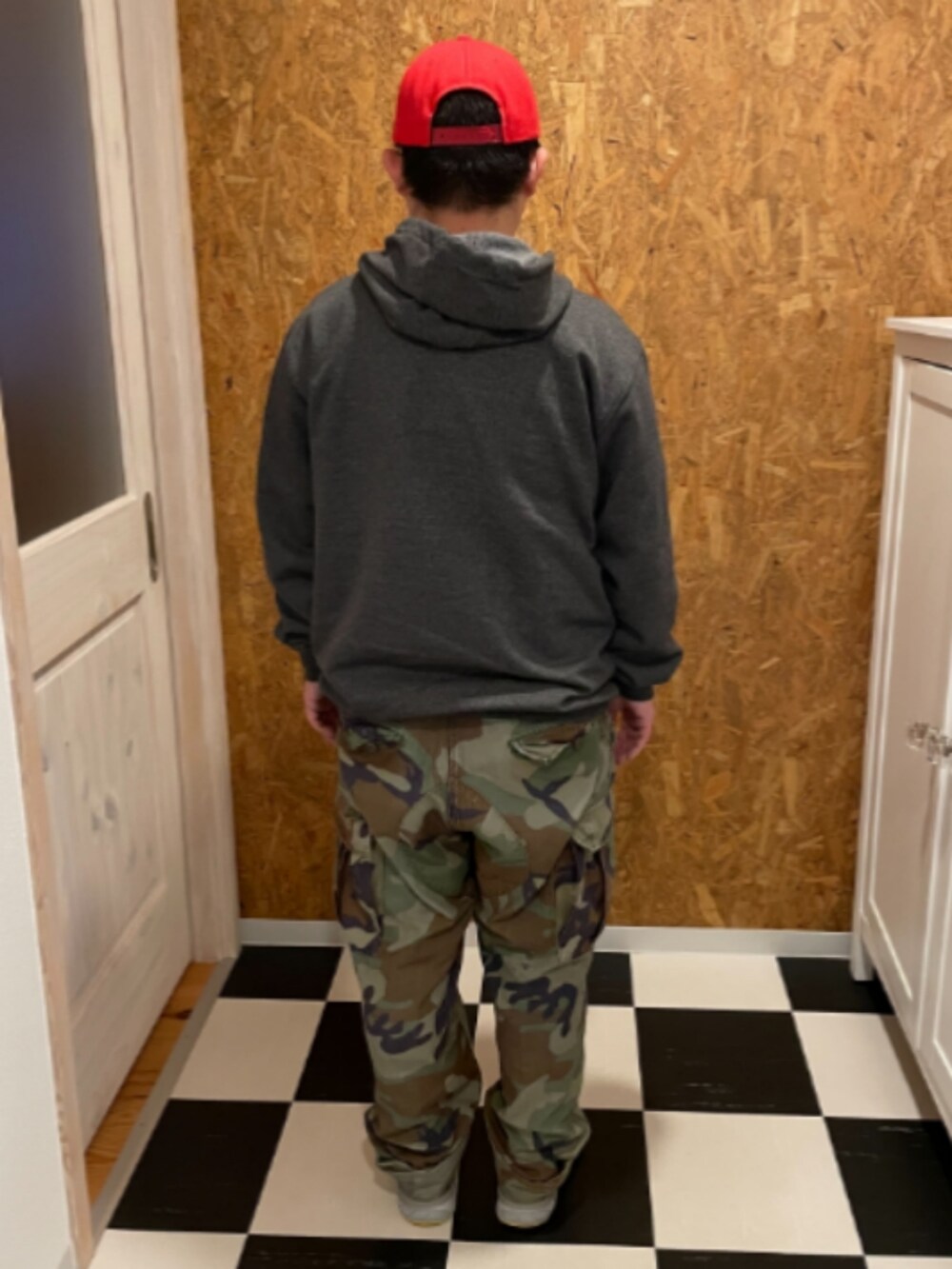 グレー系のパーカー、グリーン系のカーゴパンツ、ホワイト系のスニーカーを着用したメンズの春コーディネートの2枚目の写真