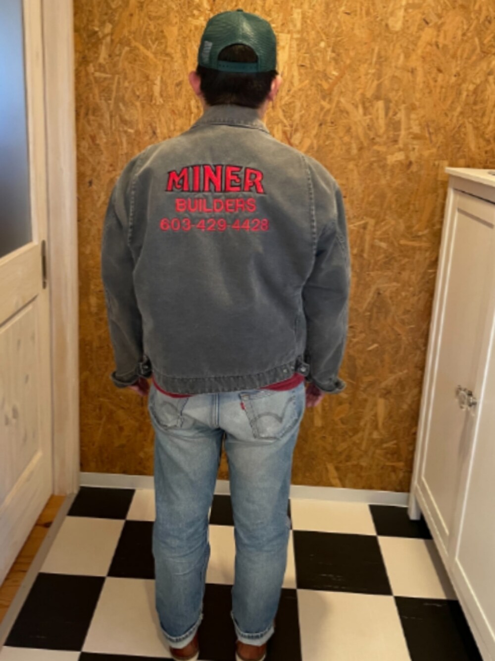 レッド系のポロシャツ、ブラック系のジャケット/アウター、ブルー系のデニムパンツを着用したメンズの春コーディネートの2枚目の写真