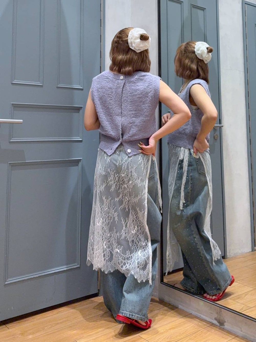 ブルー系のデニムパンツ、レッド系のサンダル、パープル系のニット/セーターを着用したレディースの夏コーディネートの3枚目の写真