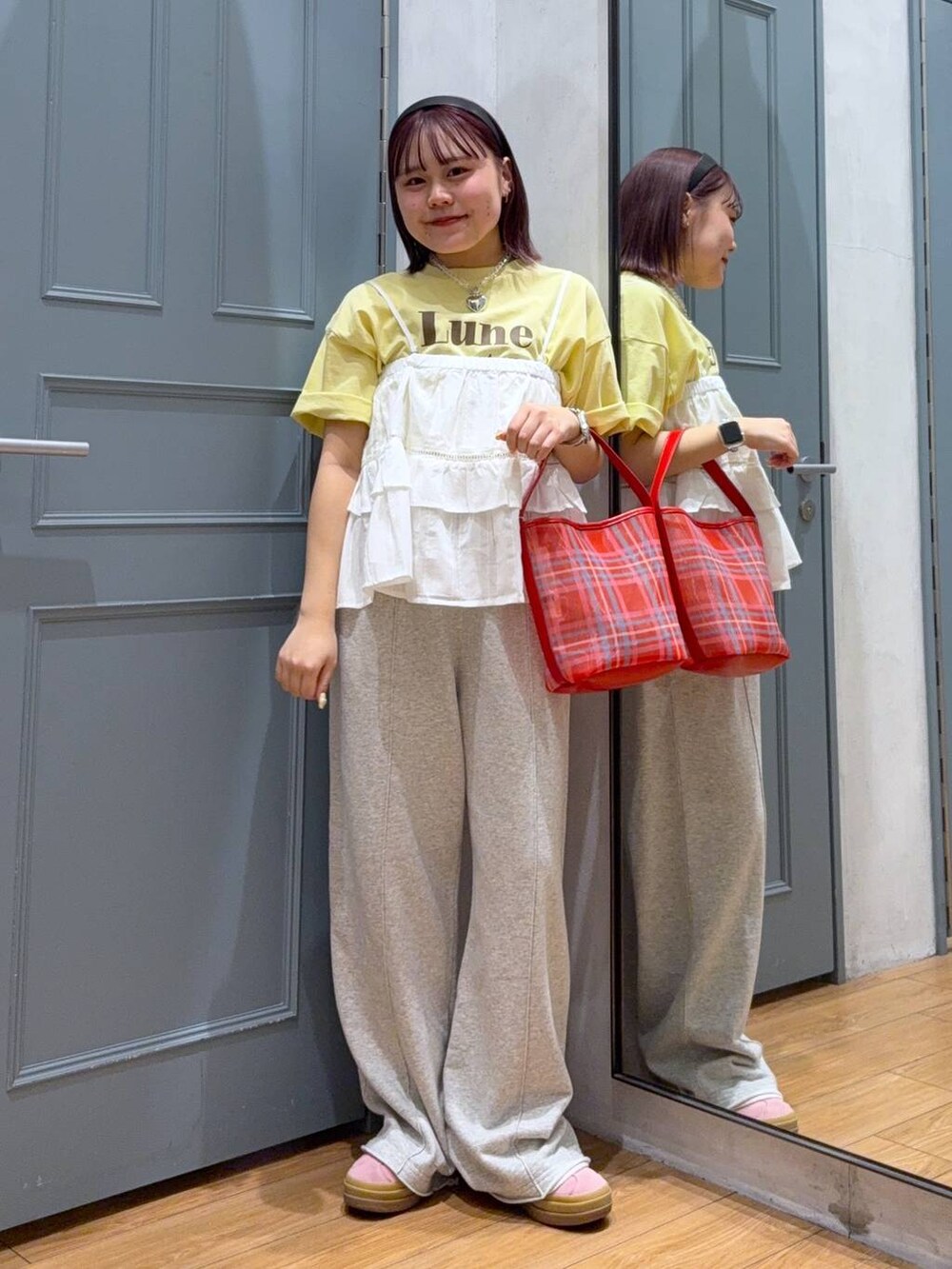 イエロー系のTシャツ/カットソー、レッド系のトートバッグ、ホワイト系のキャミソールを着用したレディースの春コーディネートの2枚目の写真