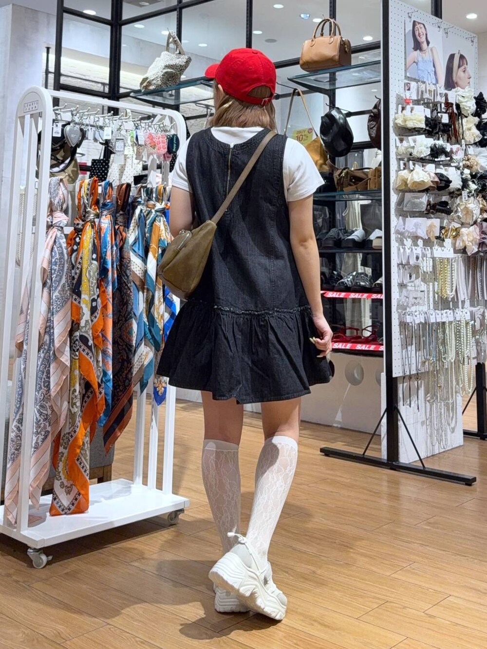 ホワイト系のTシャツ/カットソー、ブラウン系のショルダーバッグ、ホワイト系のスニーカーを着用したレディースの夏コーディネートの3枚目の写真