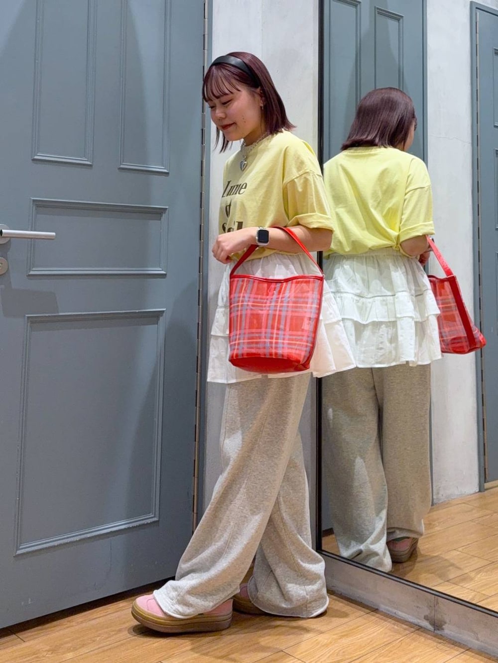 イエロー系のTシャツ/カットソー、レッド系のトートバッグ、ホワイト系のキャミソールを着用したレディースの春コーディネートの3枚目の写真