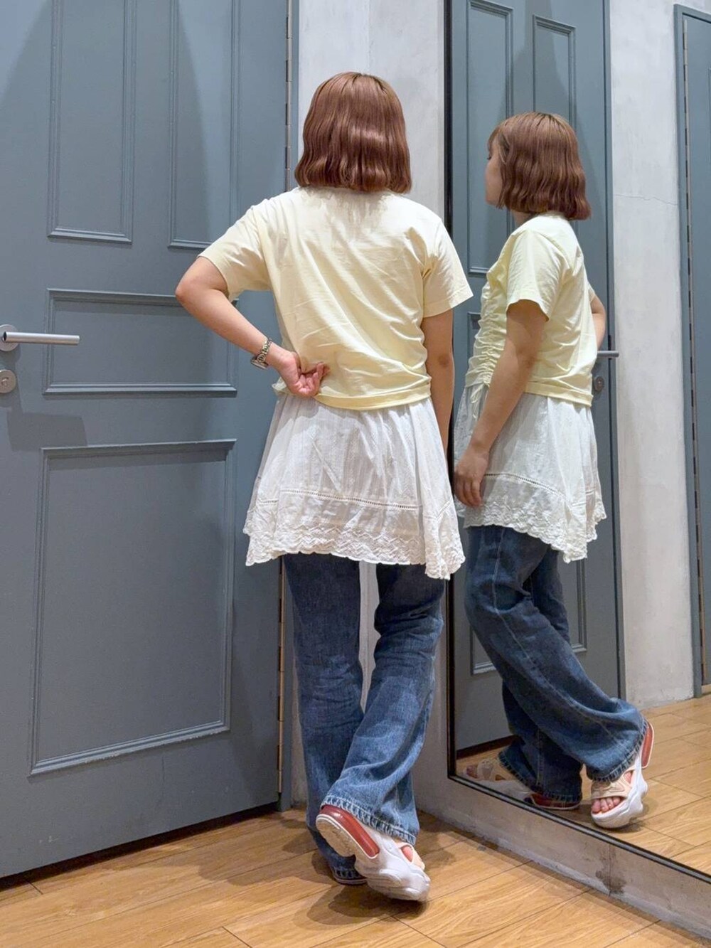 ベージュ系のTシャツ/カットソー、ホワイト系のワンピース、ブルー系のデニムパンツを着用したレディースの夏コーディネートの3枚目の写真