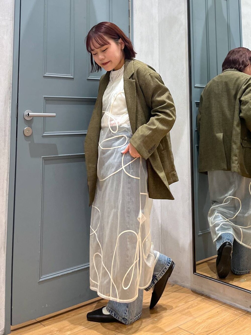 ホワイト系のTシャツ/カットソー、ブラウン系のテーラードジャケット、ブルー系のデニムパンツを着用したレディースの冬コーディネートの2枚目の写真