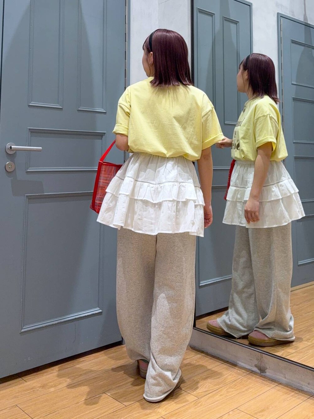 イエロー系のTシャツ/カットソー、レッド系のトートバッグ、ホワイト系のキャミソールを着用したレディースの春コーディネートの4枚目の写真