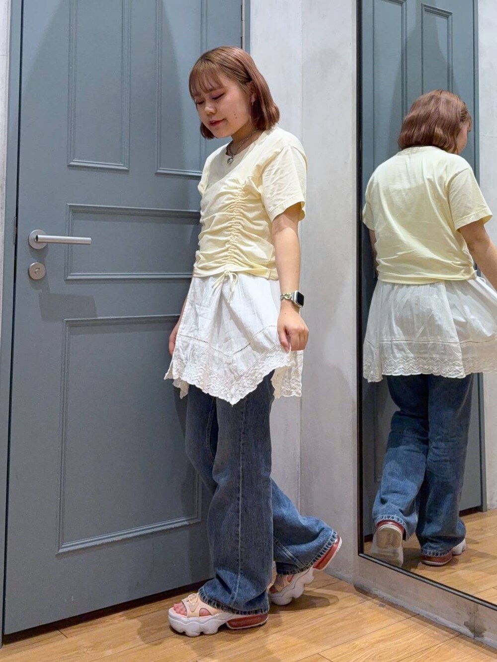 ベージュ系のTシャツ/カットソー、ホワイト系のワンピース、ブルー系のデニムパンツを着用したレディースの夏コーディネートの2枚目の写真