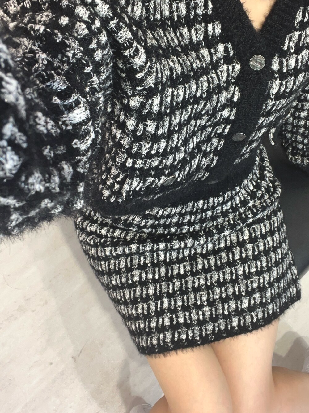 ブラック系のカーディガン/ボレロ、ブラック系のスカートを着用したレディースの冬コーディネートの4枚目の写真