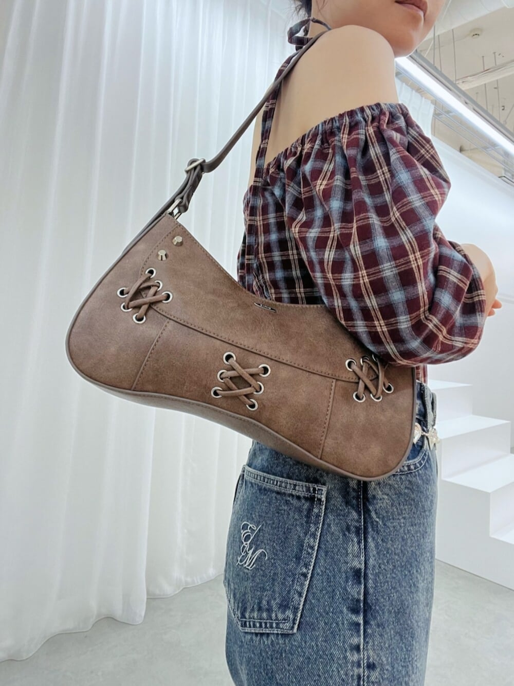 ブラウン系のショルダーバッグ、ブルー系のデニムパンツ、ブラウン系のサンダルを着用したレディースの秋コーディネートの6枚目の写真