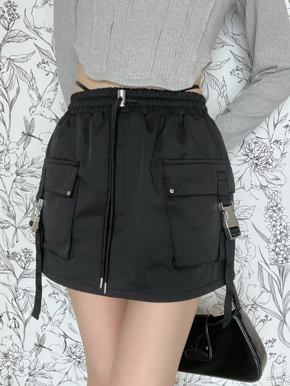 グレー系のTシャツ/カットソー、ブラック系のスカートを着用したレディースの春コーディネートの6枚目の写真