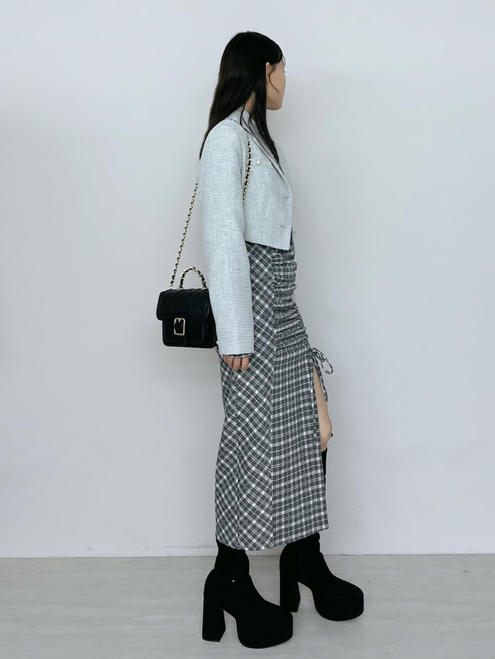 グレー系のワンピース、ブラック系のブーツ、グレー系のテーラードジャケットを着用したレディースの秋コーディネートの3枚目の写真