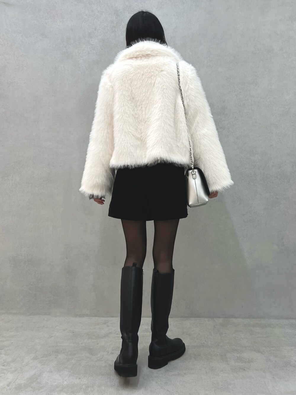 ホワイト系のその他アウター、グレー系のニット/セーター、シルバー系のショルダーバッグを着用したレディースの冬コーディネートの4枚目の写真