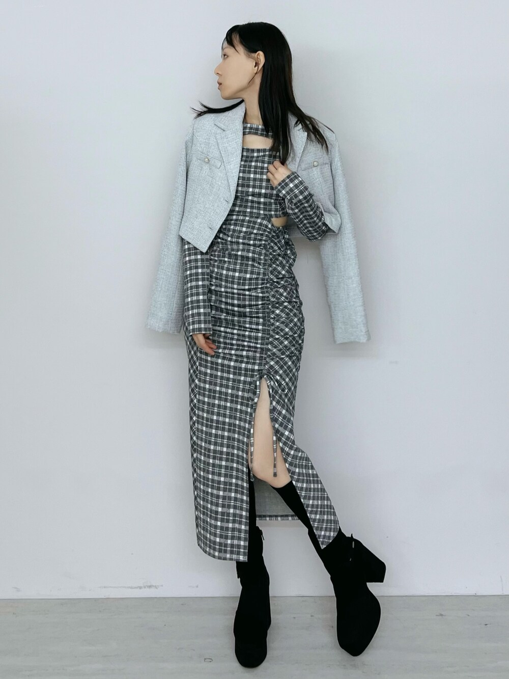グレー系のワンピース、ブラック系のブーツ、グレー系のテーラードジャケットを着用したレディースの秋コーディネートの5枚目の写真