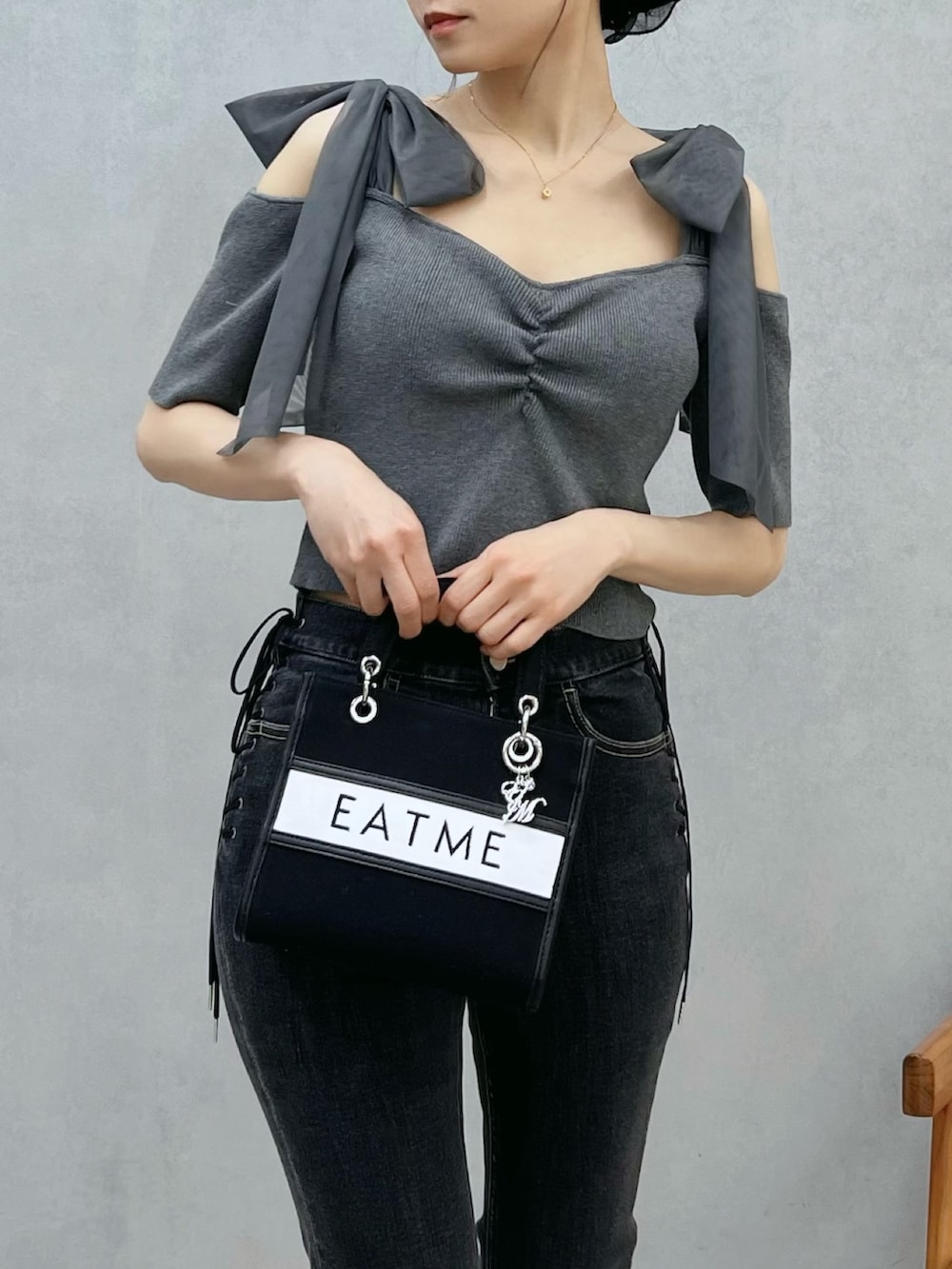 ブルー系のデニムパンツ、ブラック系のショルダーバッグ、グレー系のTシャツ/カットソーを着用したレディースの春コーディネートの5枚目の写真