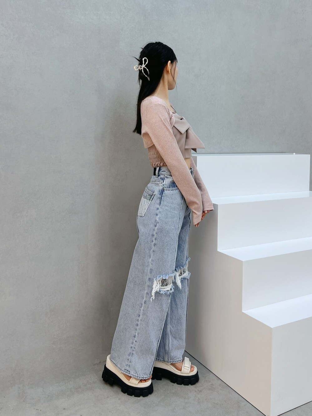 ブルー系のデニムパンツ、ホワイト系のサンダル、ピンク系のシャツ/ブラウスを着用したレディースの夏コーディネートの2枚目の写真