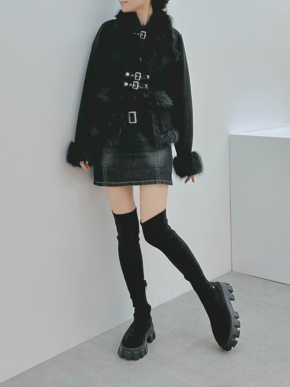 ブラック系のデニムスカート、ブラック系のブーツ、ブラック系のブルゾンを着用したレディースの秋コーディネートの5枚目の写真