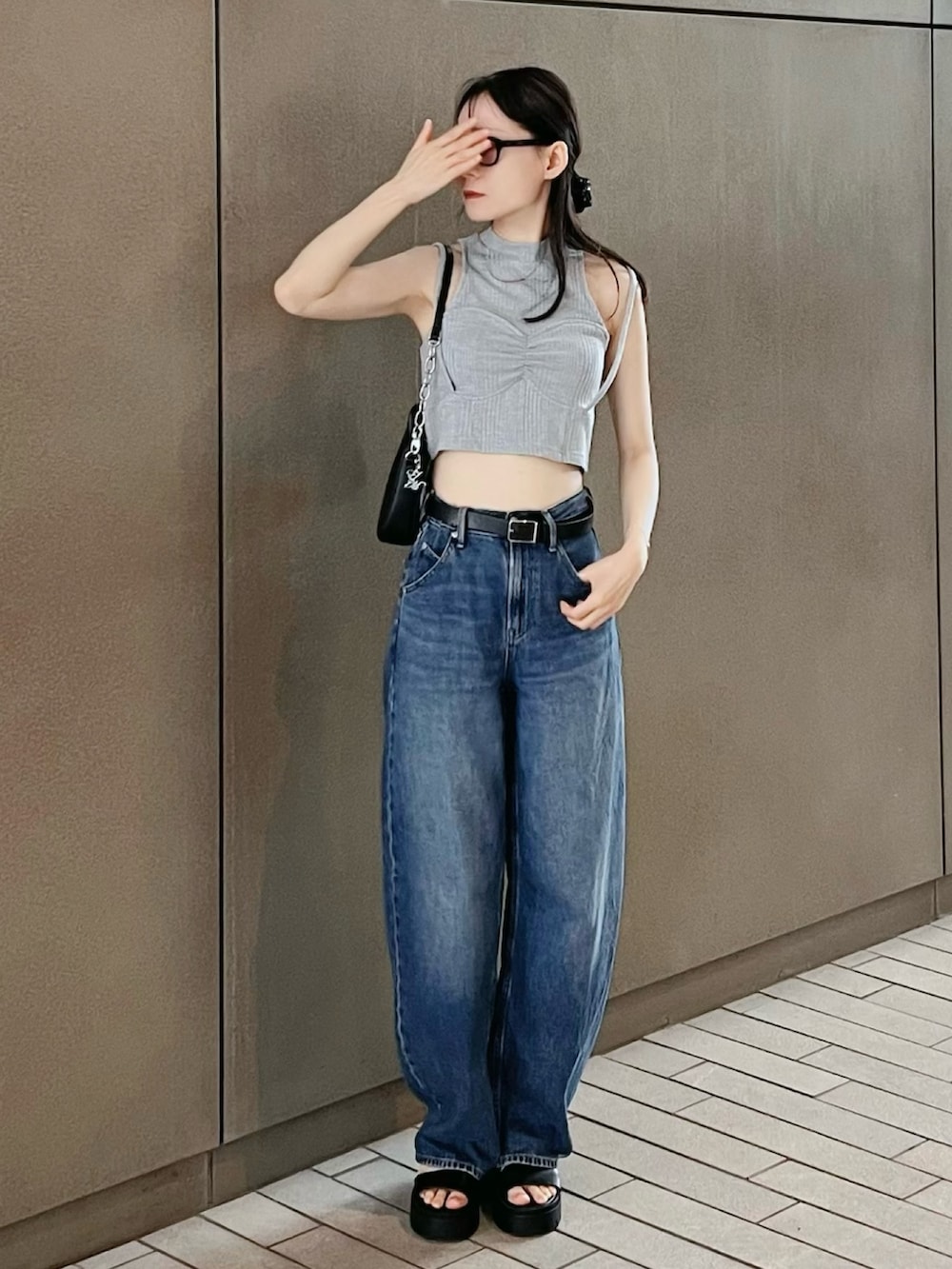 グレー系のタンクトップを着用したレディースの夏コーディネートの2枚目の写真