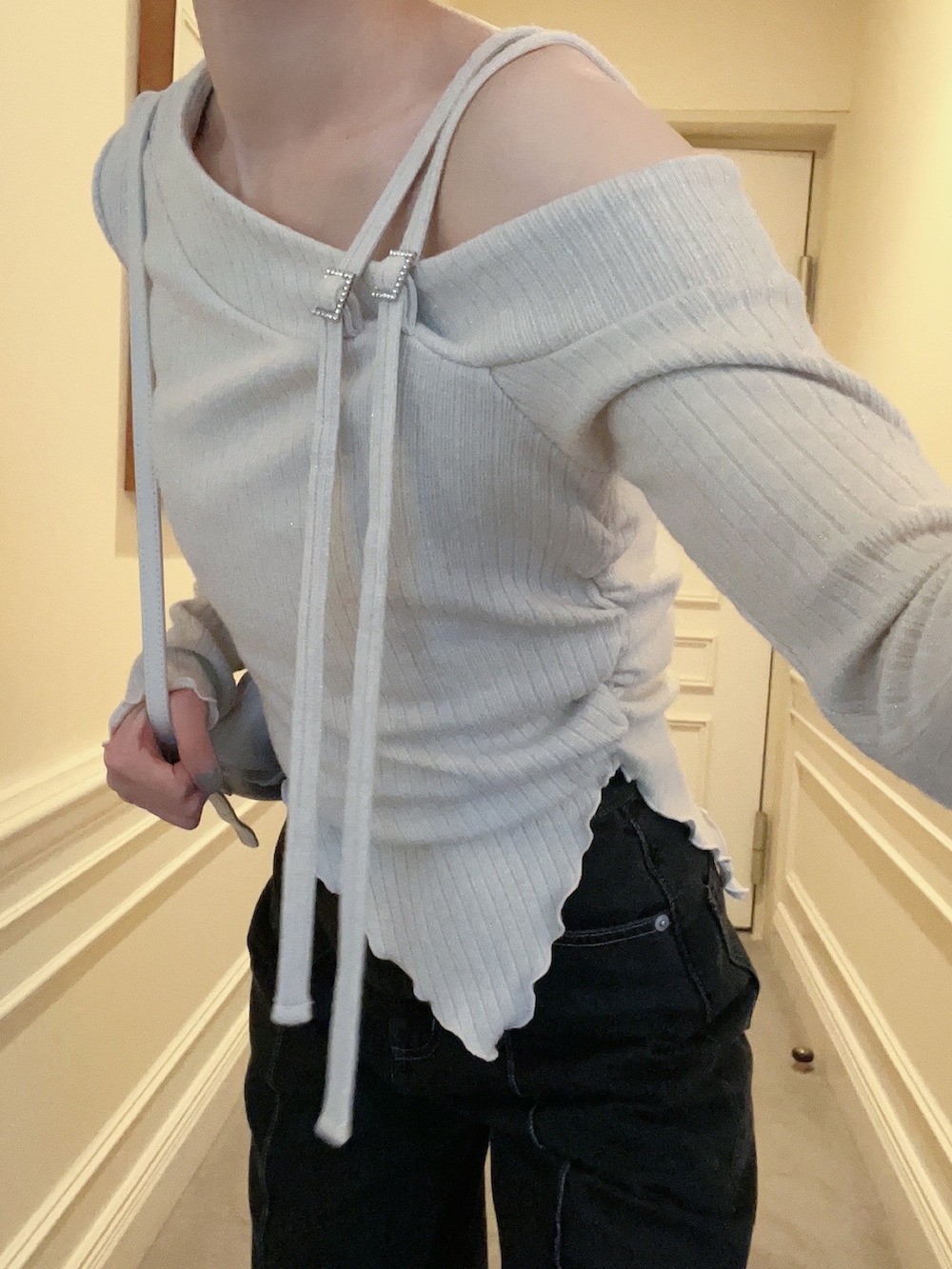 ブラック系のデニムパンツ、ホワイト系のショルダーバッグ、ホワイト系のTシャツ/カットソーを着用したレディースの冬コーディネートの4枚目の写真