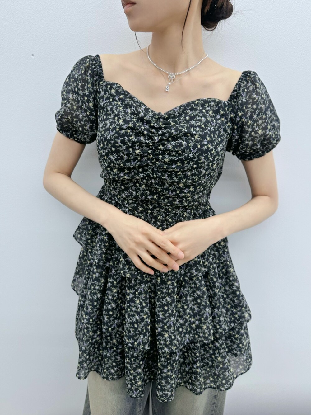 ブラック系のワンピース、ブルー系のデニムパンツ、シルバー系のネックレスを着用したレディースの夏コーディネートの6枚目の写真