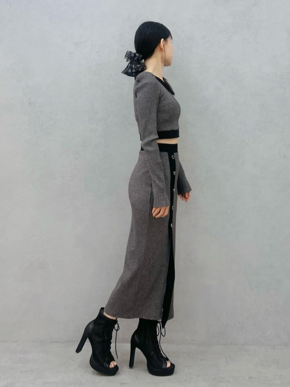 ブラック系のブーツ、グレー系のスカート、グレー系のTシャツ/カットソーを着用したレディースの冬コーディネートの2枚目の写真