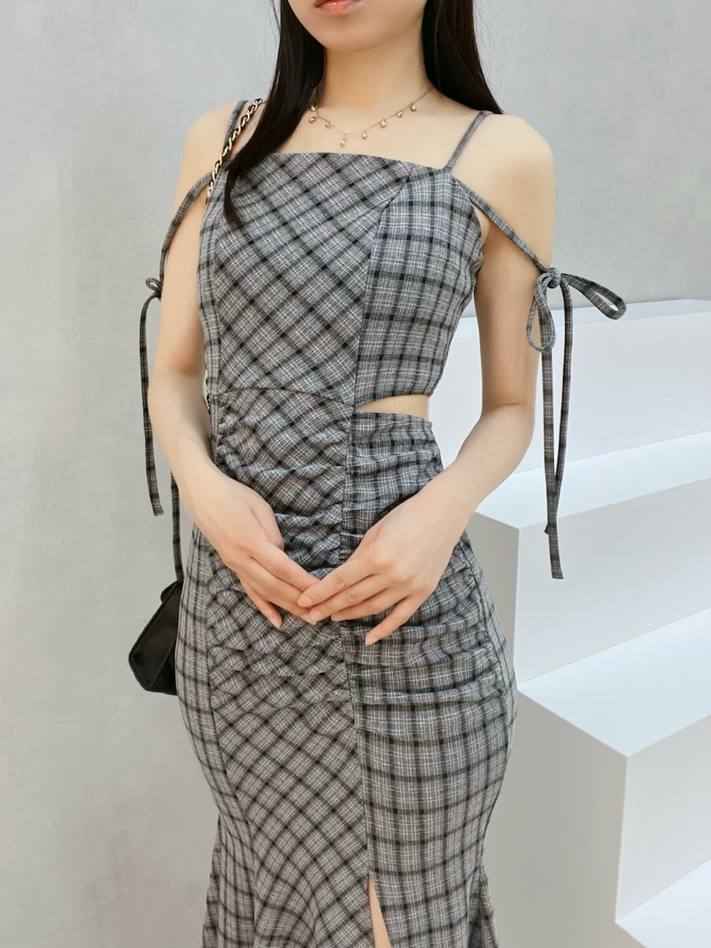 グレー系のワンピース、ブラック系のハンドバッグ、ブラック系のサンダルを着用したレディースの夏コーディネートの5枚目の写真