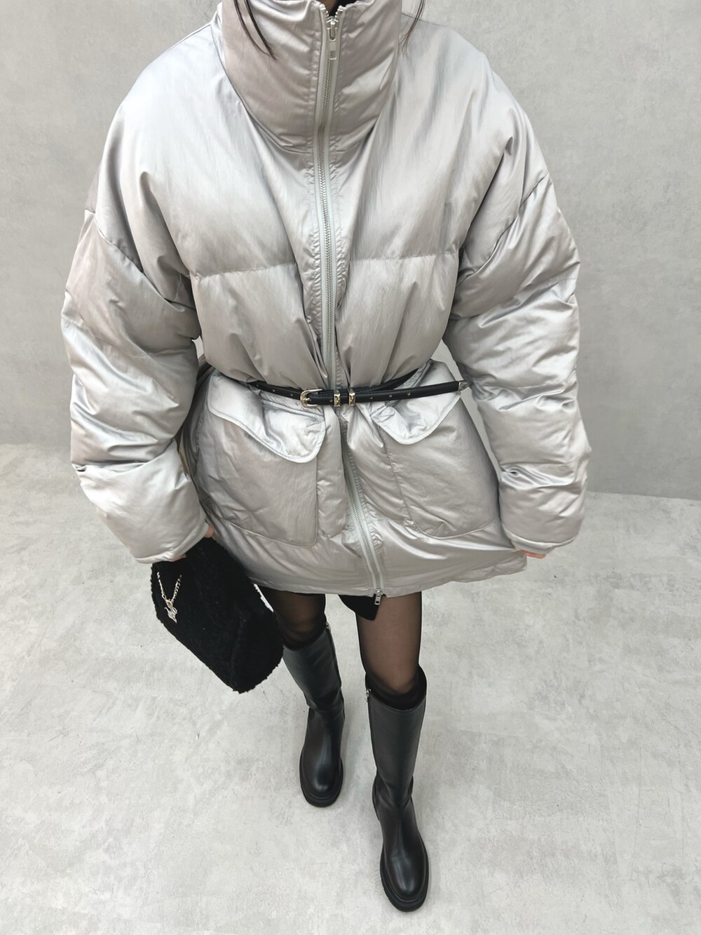 グレー系のブルゾン、ブラック系のハンドバッグ、ブラック系のベルトを着用したレディースの冬コーディネートの5枚目の写真