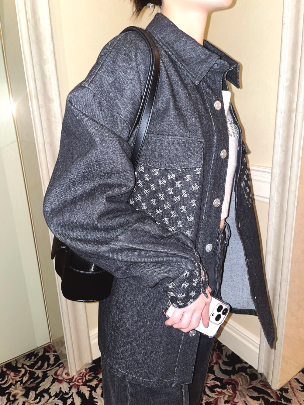 ブラック系のデニムジャケット、ブラック系のデニムパンツ、ピンク系のニット/セーターを着用したレディースの冬コーディネートの3枚目の写真