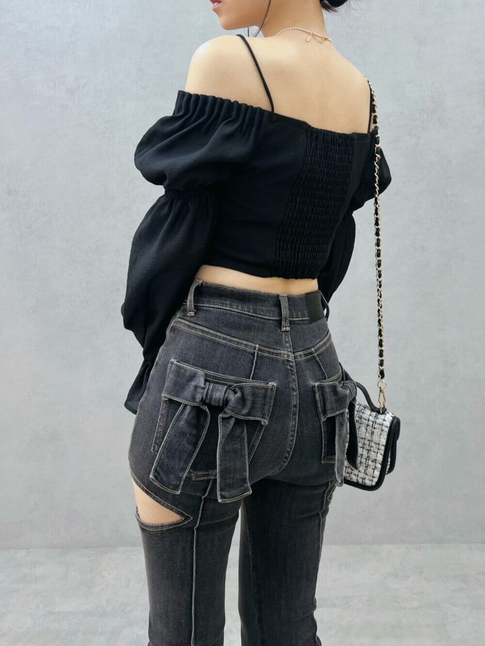 ブラック系のデニムパンツ、ホワイト系のハンドバッグ、ブラック系のシャツ/ブラウスを着用したレディースの夏コーディネートの7枚目の写真