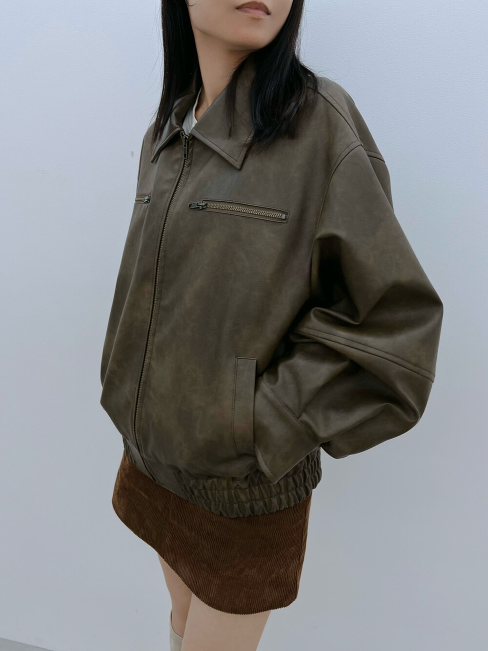 ブラウン系のブルゾン、ホワイト系のブーツを着用したレディースの秋コーディネートの6枚目の写真