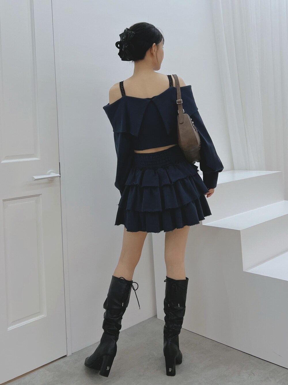 ブルー系のスカート、ブルー系のTシャツ/カットソー、ブラック系のブーツを着用したレディースの秋コーディネートの4枚目の写真