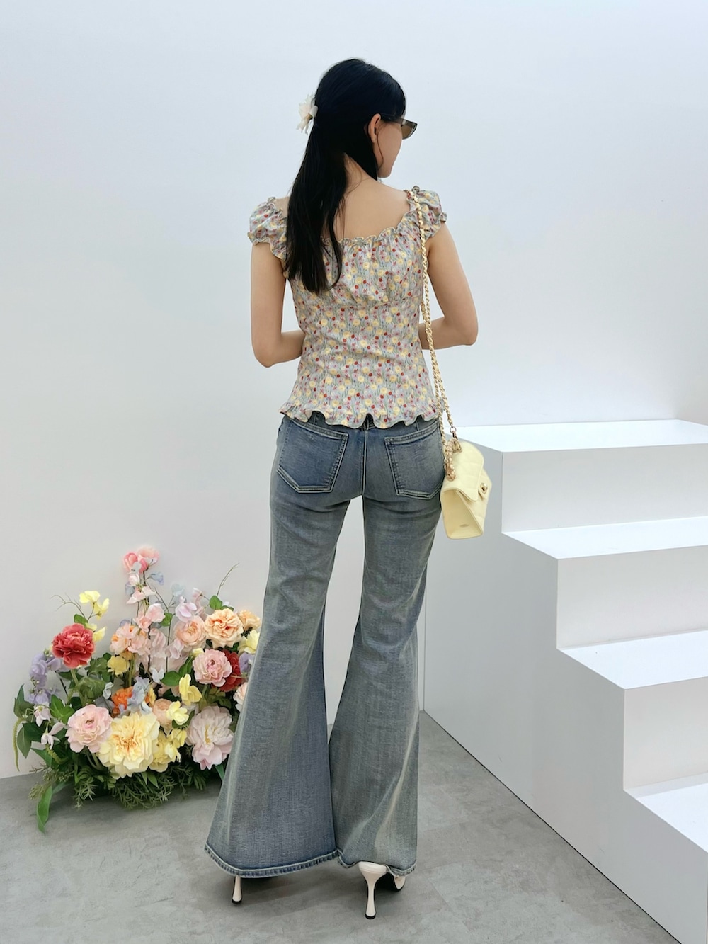 ブルー系のデニムパンツ、イエロー系のハンドバッグ、ブルー系のシャツ/ブラウスを着用したレディースの春コーディネートの3枚目の写真