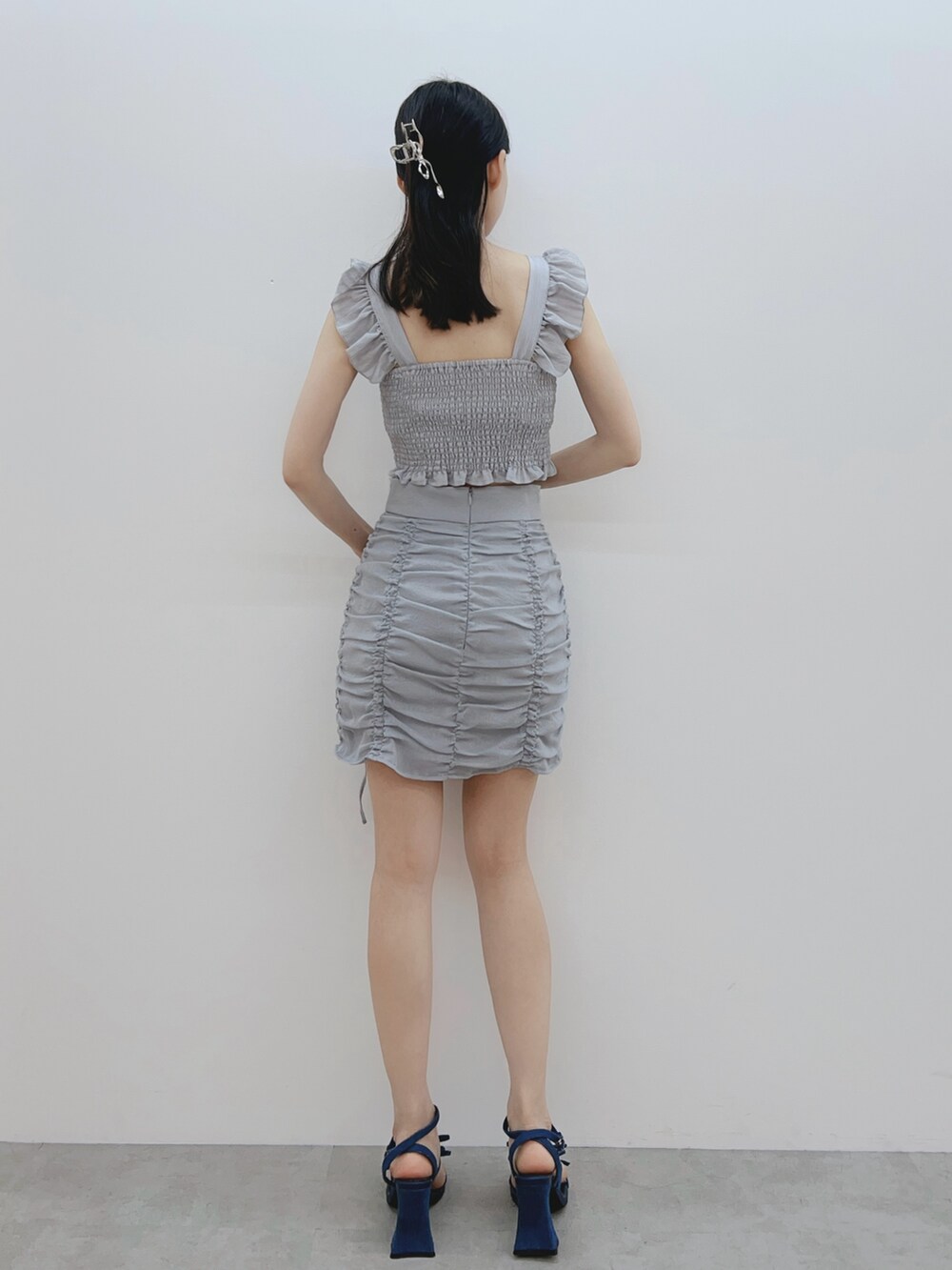 グレー系のシャツ/ブラウス、ブルー系のスカート、ブルー系のサンダルを着用したレディースの春コーディネートの5枚目の写真