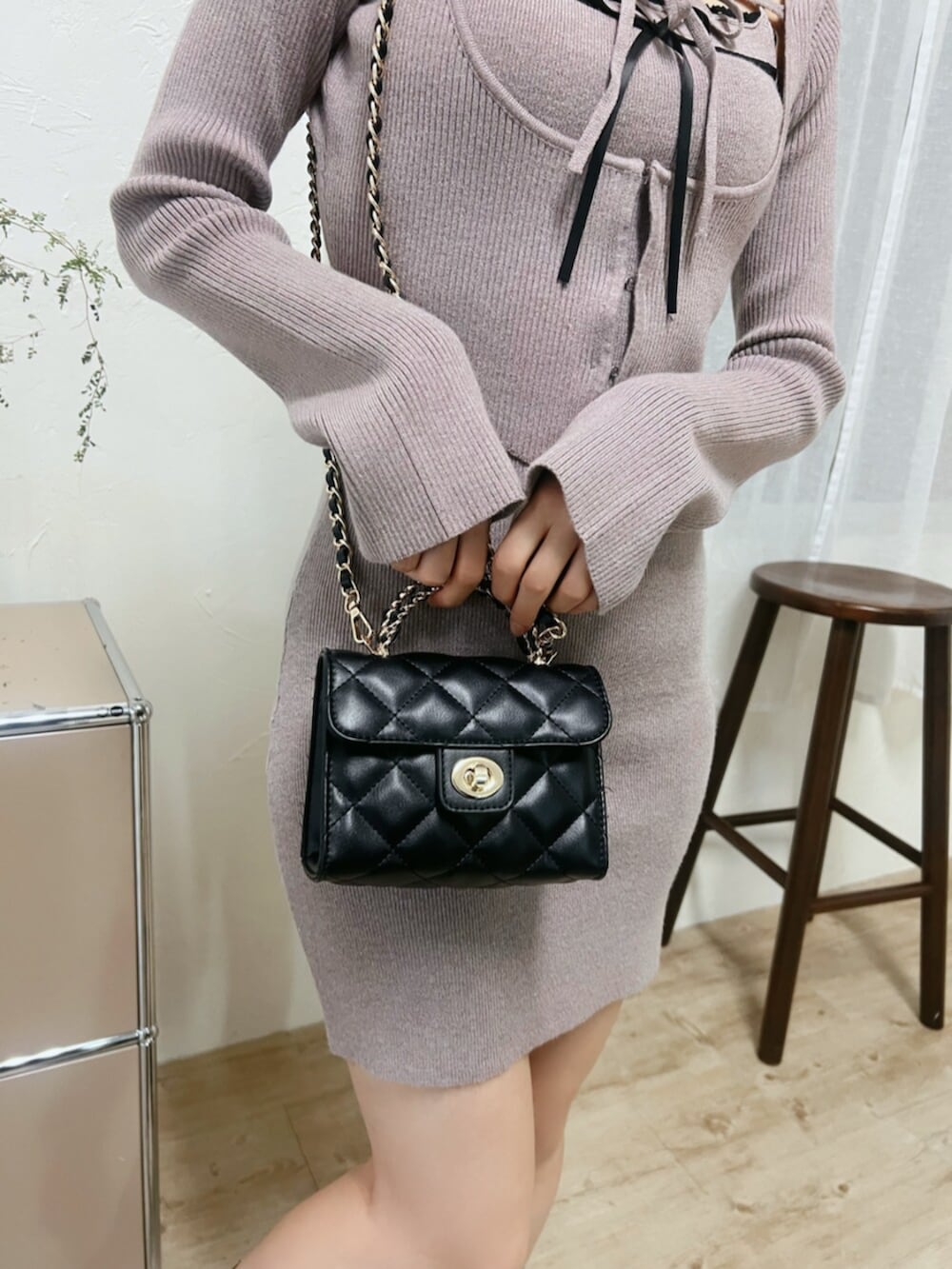 ブラック系のブーツ、ブラック系のハンドバッグ、ベージュ系のワンピースを着用したレディースの冬コーディネートの6枚目の写真