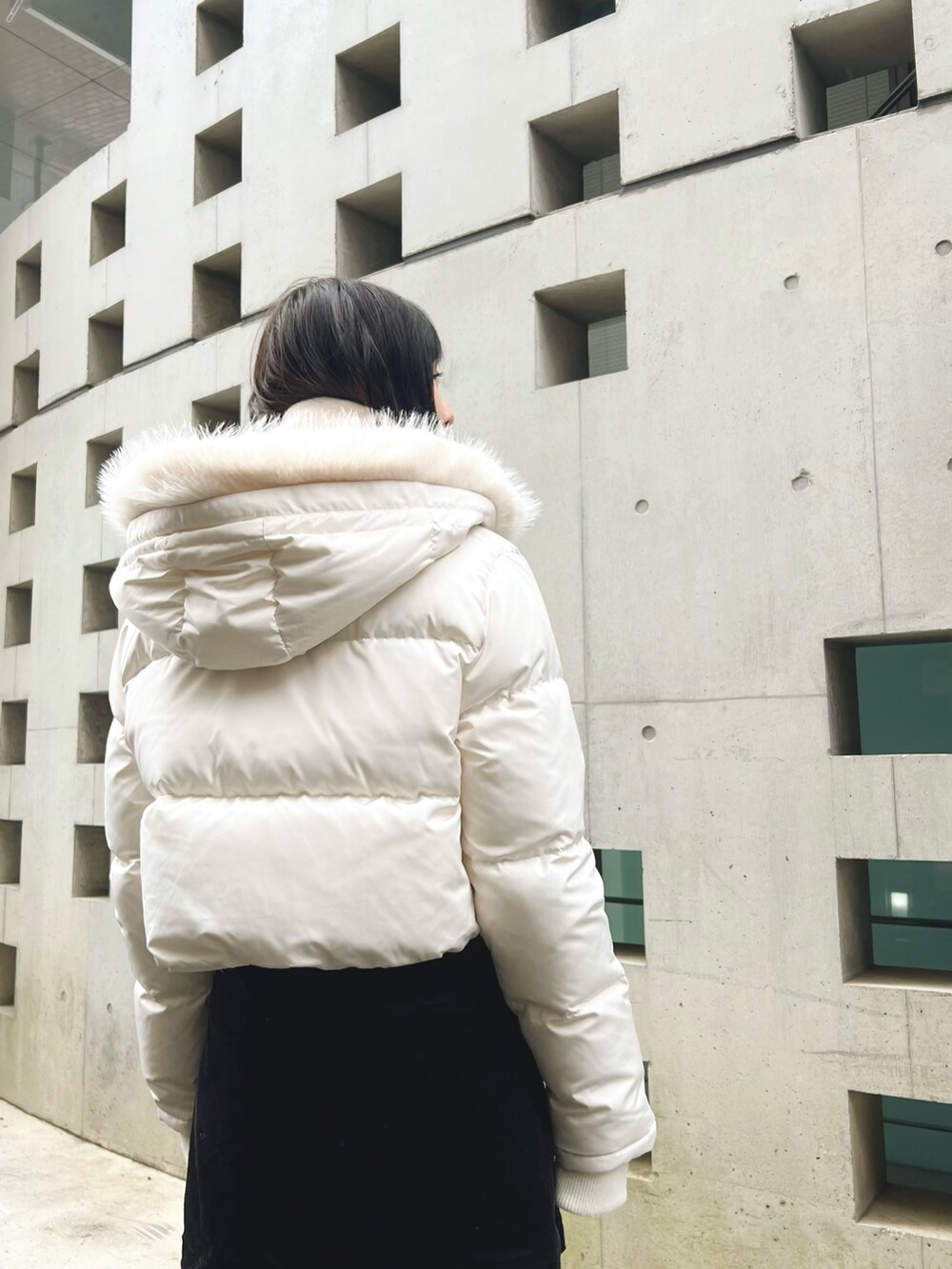 ホワイト系のブルゾン、ホワイト系のマフラーを着用したレディースの冬コーディネートの3枚目の写真