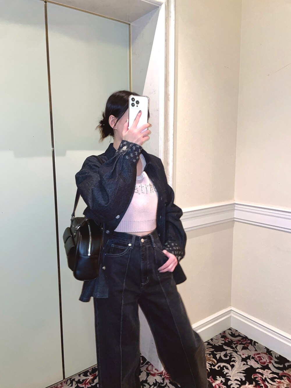 ブラック系のデニムジャケット、ブラック系のデニムパンツ、ピンク系のニット/セーターを着用したレディースの冬コーディネートの2枚目の写真