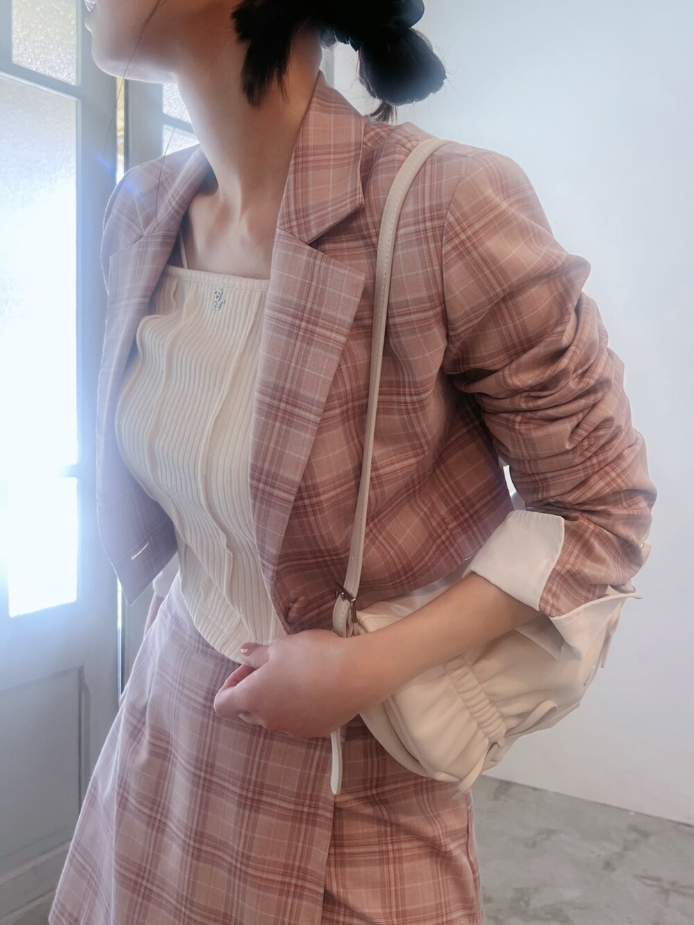 ピンク系のスカート、ホワイト系のショルダーバッグ、ピンク系のテーラードジャケットを着用したレディースの春コーディネートの7枚目の写真