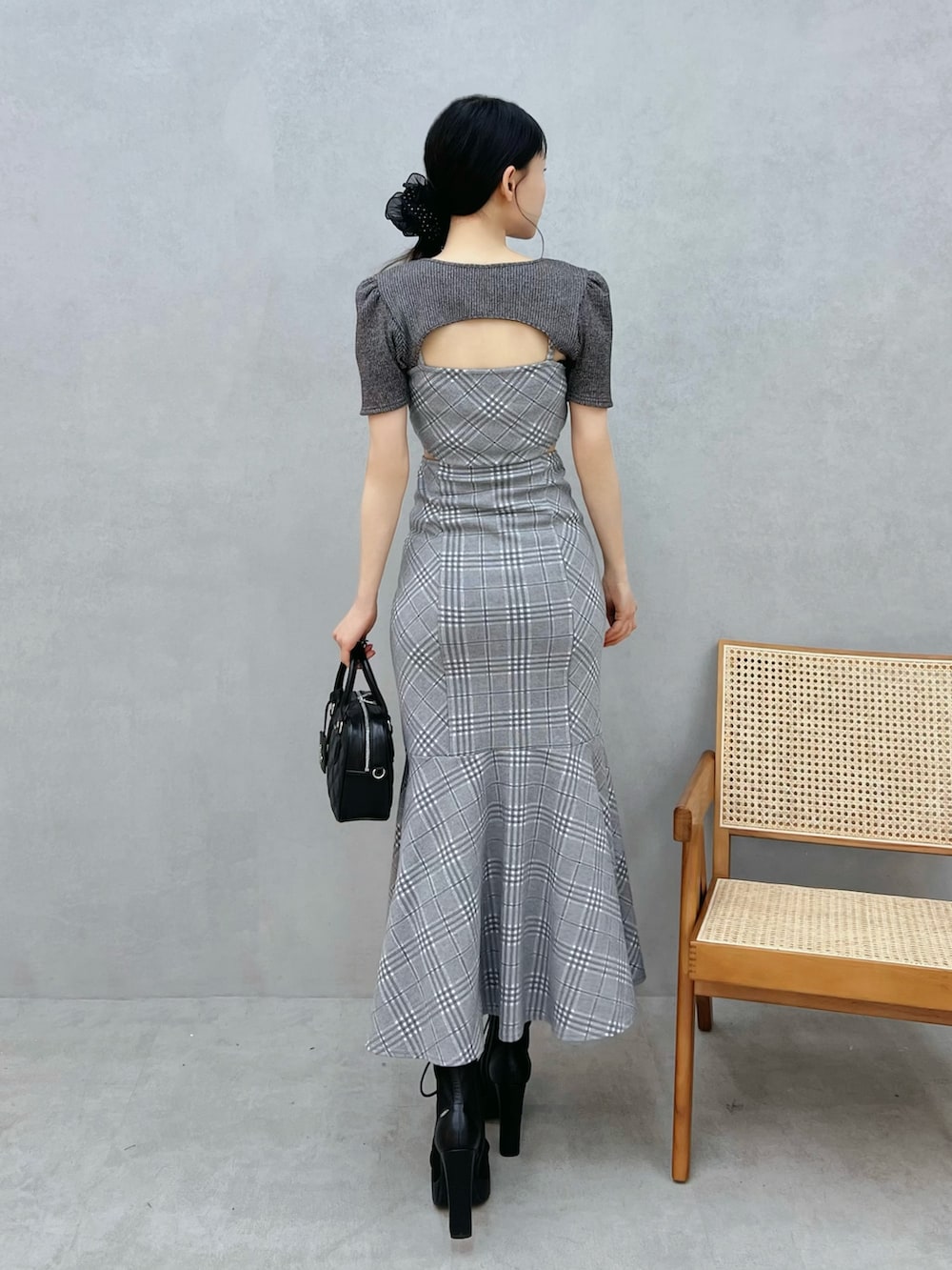 グレー系のワンピース、ブラック系のブーツ、ブラック系のシュシュを着用したレディースの春コーディネートの3枚目の写真