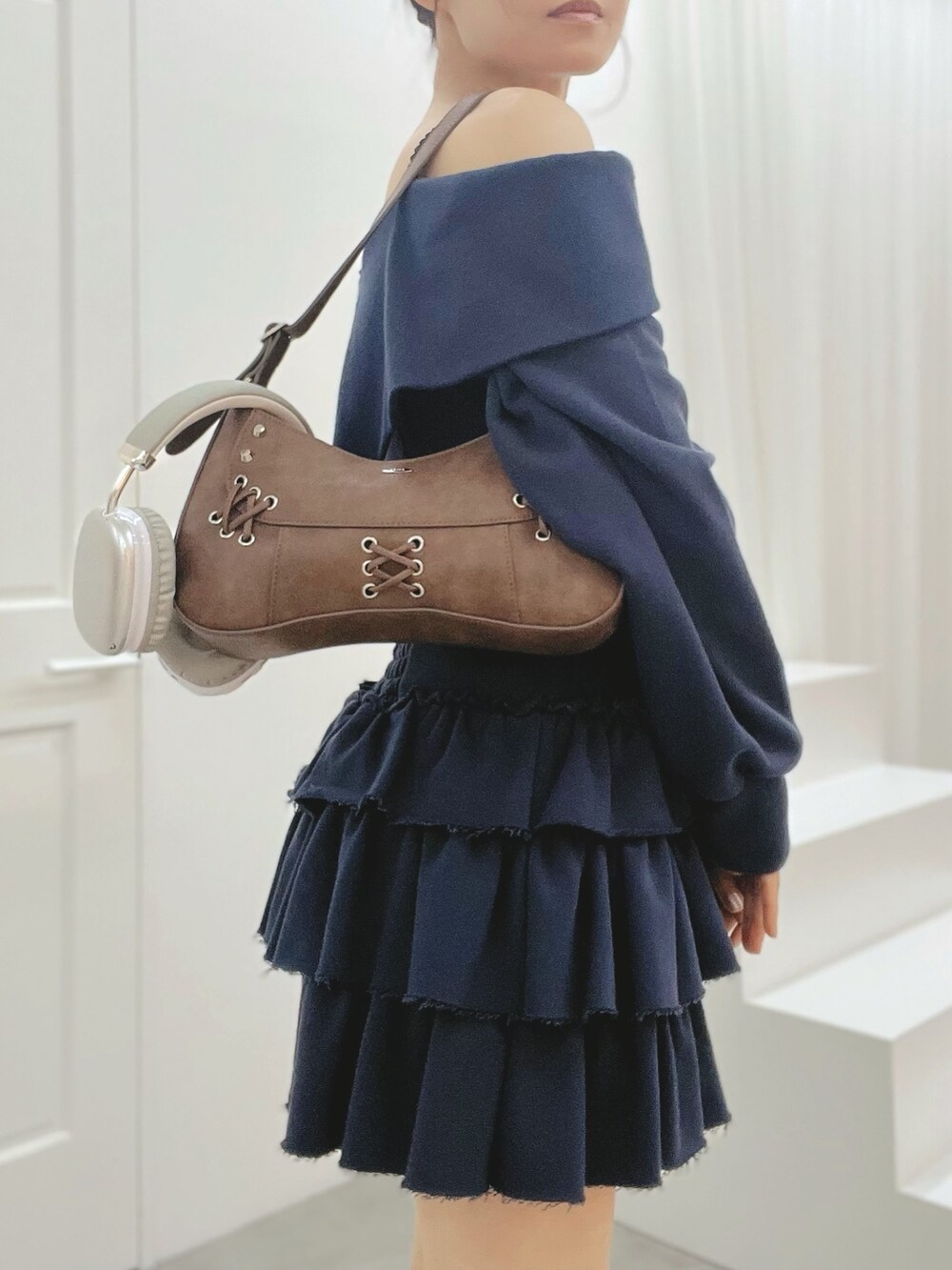 ブルー系のスカート、ブルー系のTシャツ/カットソー、ブラック系のブーツを着用したレディースの秋コーディネートの6枚目の写真