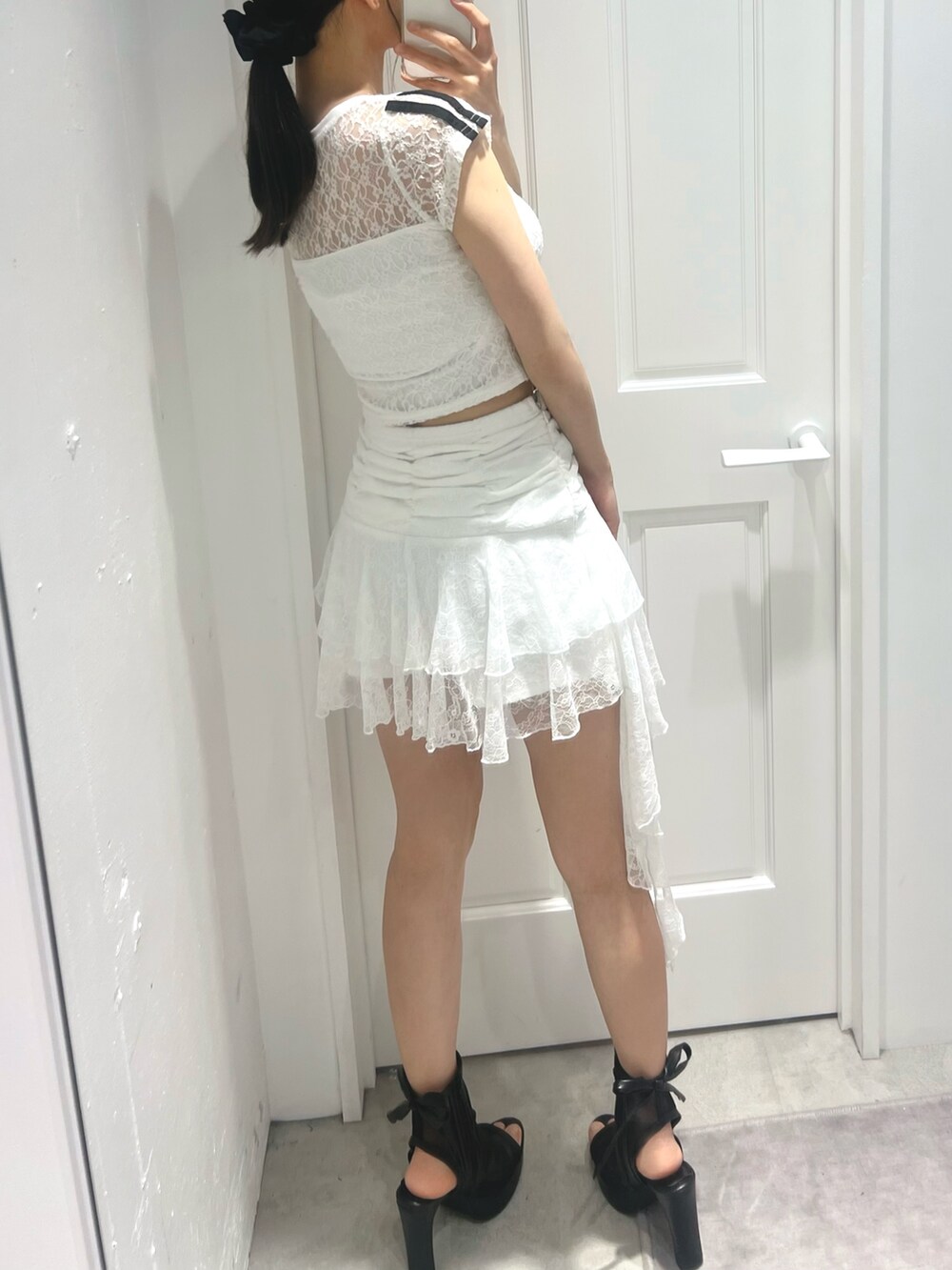 ホワイト系のスカート、ホワイト系のTシャツ/カットソー、ブラック系のサンダルを着用したレディースの春コーディネートの5枚目の写真