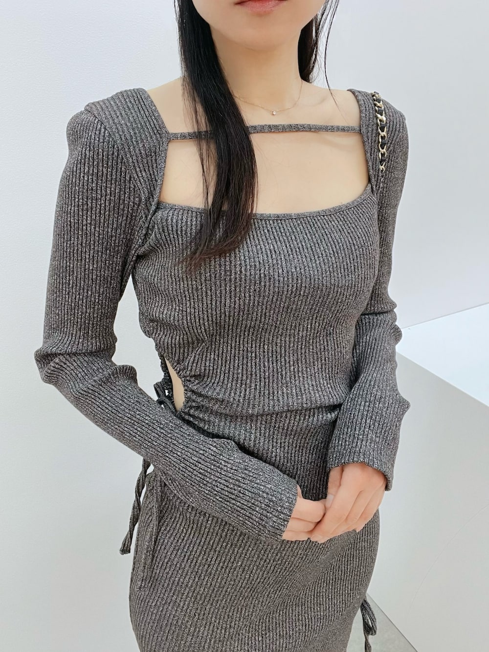 ブラック系のサンダル、グレー系のワンピース、ブラック系のハンドバッグを着用したレディースの春コーディネートの6枚目の写真