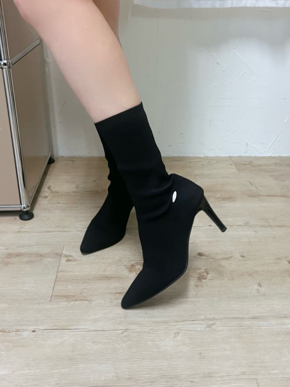 ブラック系のブーツ、ブラック系のハンドバッグ、ベージュ系のワンピースを着用したレディースの冬コーディネートの7枚目の写真