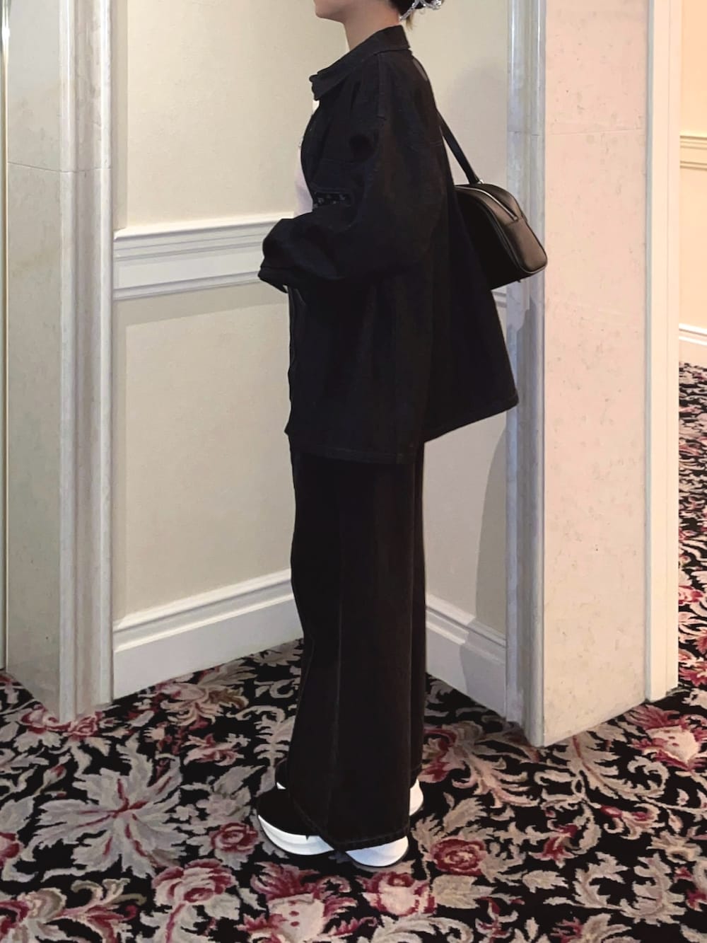 ブラック系のデニムジャケット、ブラック系のデニムパンツ、ピンク系のニット/セーターを着用したレディースの冬コーディネートの6枚目の写真